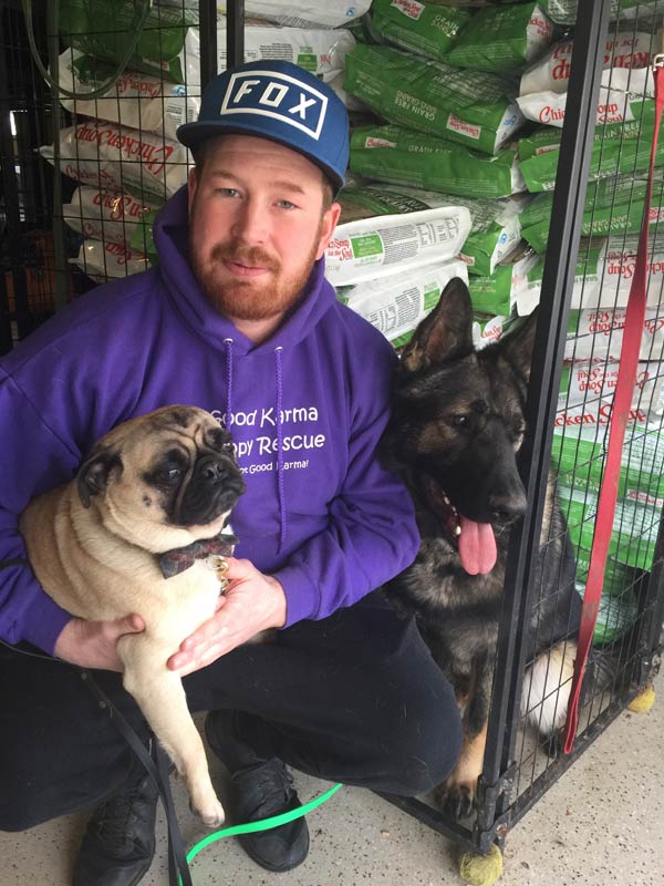 FABFAS Good Karma: man wearing Good Karma hoodie, crouching next two two dogs and dog food bags